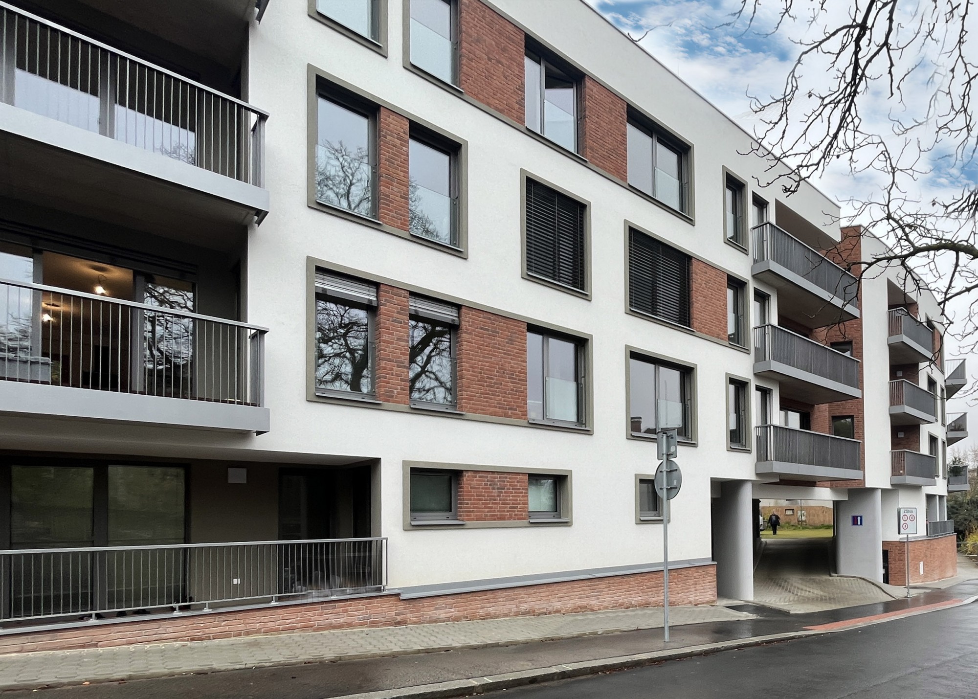 Fasáda bytového domu s cihlovými pásky